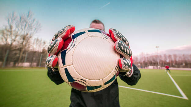 Torwart hält Fußball fest