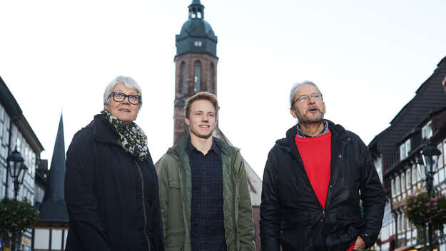 Kirchenmitglieder stehen vor einer Kirche.