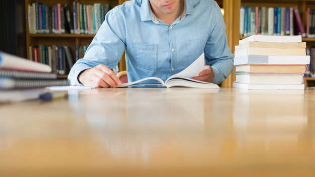 Ein Mann liest in einer Bibliothek