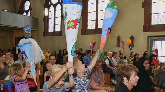 Bei einem ökumenischen Einschulungsgottesdienst in Frankfurt zeigen die Kinder ihre Schultüten.