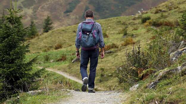 Wanderer entfernt sich auf Bergpfad