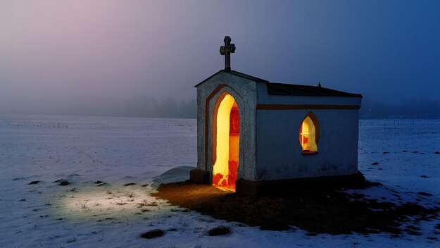 Mit Kerzen erleuchtete Kapelle im Winter