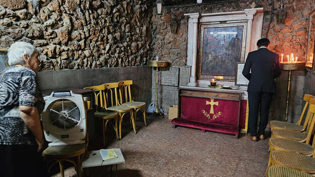 In der Syrisch-Orthodoxen Sankt-Georgskapelle, Damaskus: Eine alte Frau schaut zu einem Mann, der betet