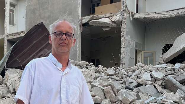 Pfarrer Christian Kurzke vor einem zerstörten Haus in Syrien