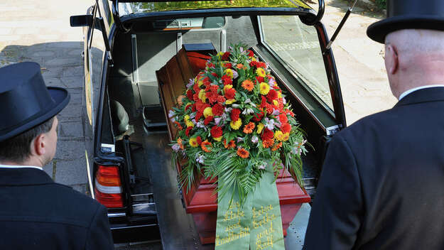 Bestattungsunternehmer bei der Vorbereitung einer Trauerfeier und der anschliessenden Beerdigung auf einem Friedhof .