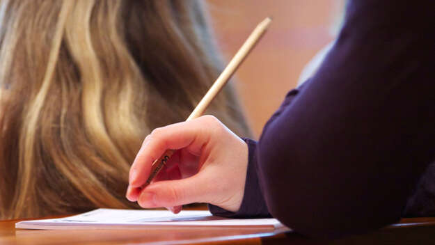 Symbolfoto mit einer Hand, die einen Stift hält