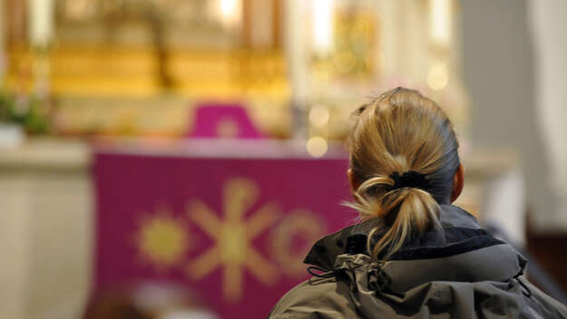 Eine Frau sitzt in einer Kirche