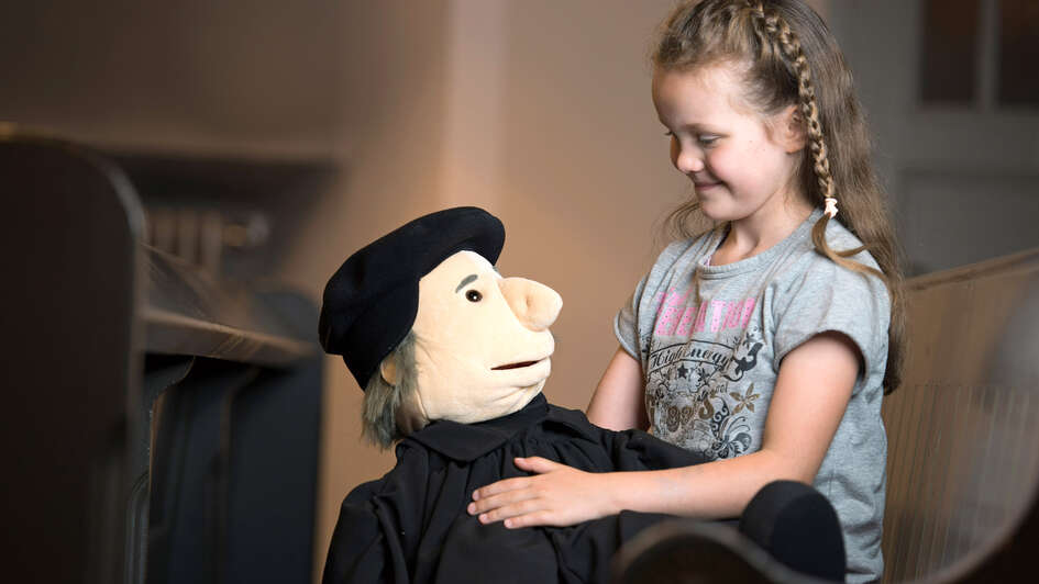 Mädchen spielt mit Martin-Luther-Handpuppe