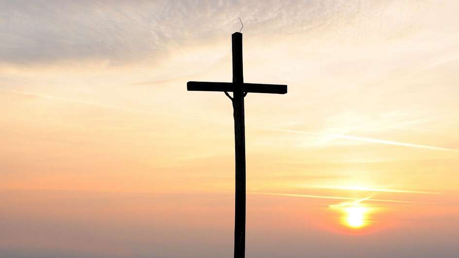 Bergkreuz vor aufgehender Sonne