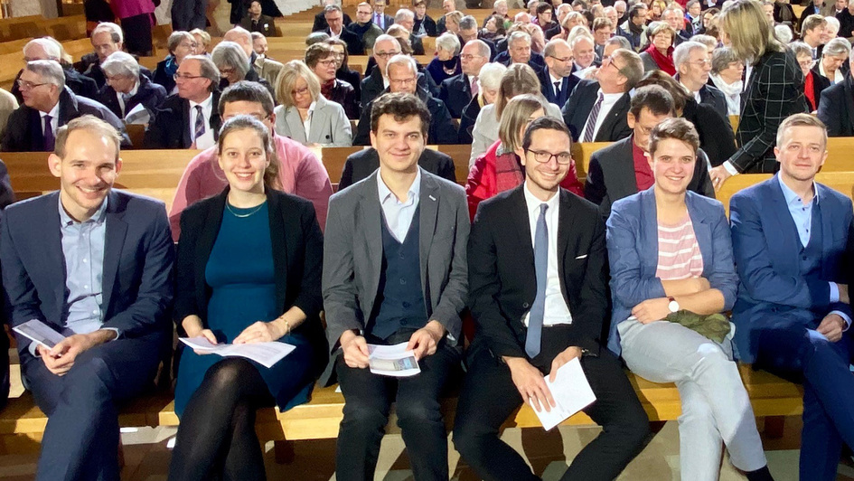 Jugenddelegierte der EKD-Synode sitzen auf einer Kirchenbank in der Dresdner Kreuzkirche