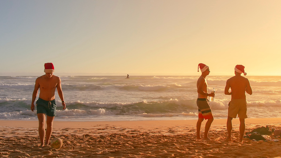 Junge Männer mit Weihnachtsmütze a, Strand in Australien