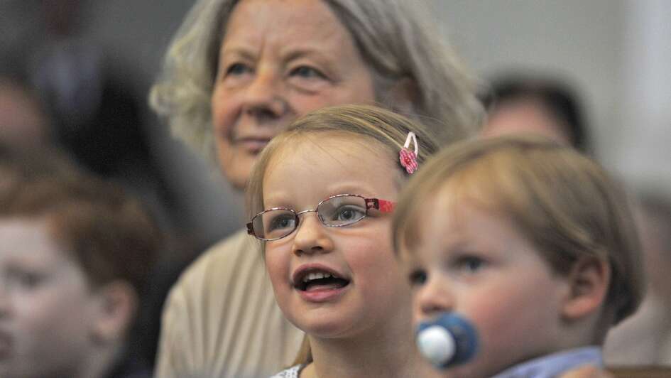 Gottesdienstbild: Eine Frau und zwei Kinder in den Kirchenbänken