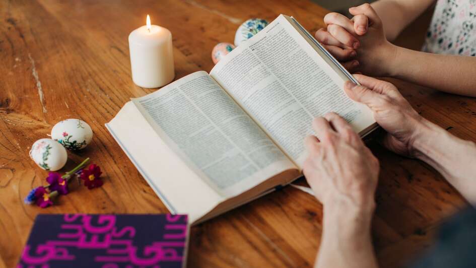 Hände blättern in einer Bibel auf dem Tisch