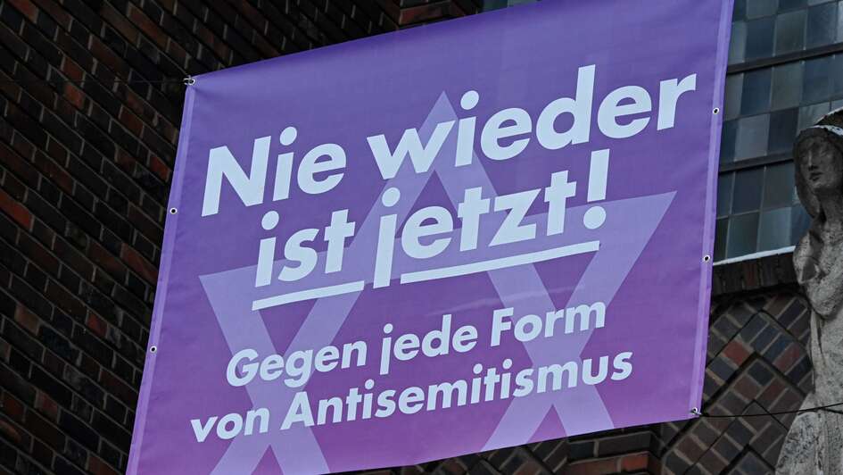 Banner mit der Aufschrift 'Nie wieder ist jetzt! Gegen jede Form von Antisemitismus' an der katholischen St. Bonifatiuskirche in Frankfurt-Sachsenhausen