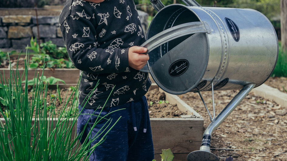 Kind mit Gießkanne im Garten