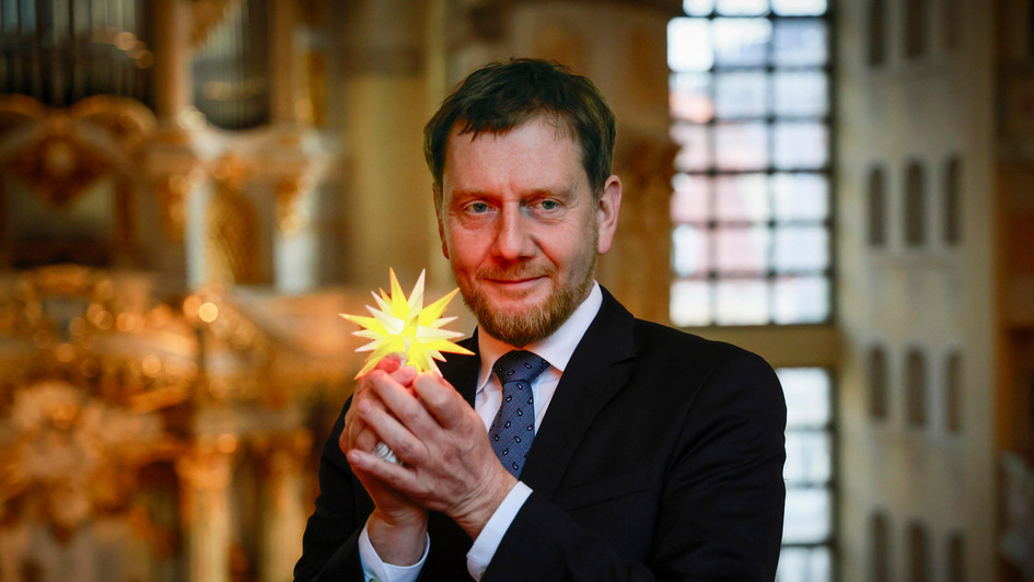 Praesentation der neuen Herrnhuter Sterne Edition 'Frauenkirche Dresden' in der Frauenkirche in Dresden. (Foto vom 25.11.2024: Der saechsische Ministerpraesident Michael Kretschmer (CDU) hat das erste Exemplar uebergeben bekommen).