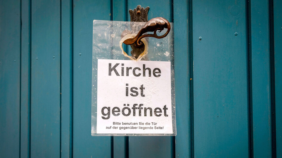 Schild 'Kirche ist geoeffnet' an der Tuer der St.-Andreas-Kirche in Verden (Niedersachsen), 09.08.2019.