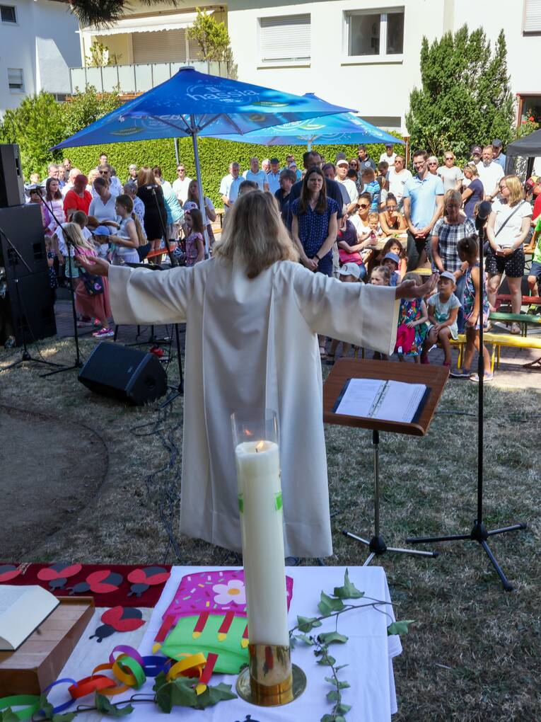 Bei einem Freiluftgottesdienst in Bad Vilbel segnet die Pfarrerin die Gemeinde