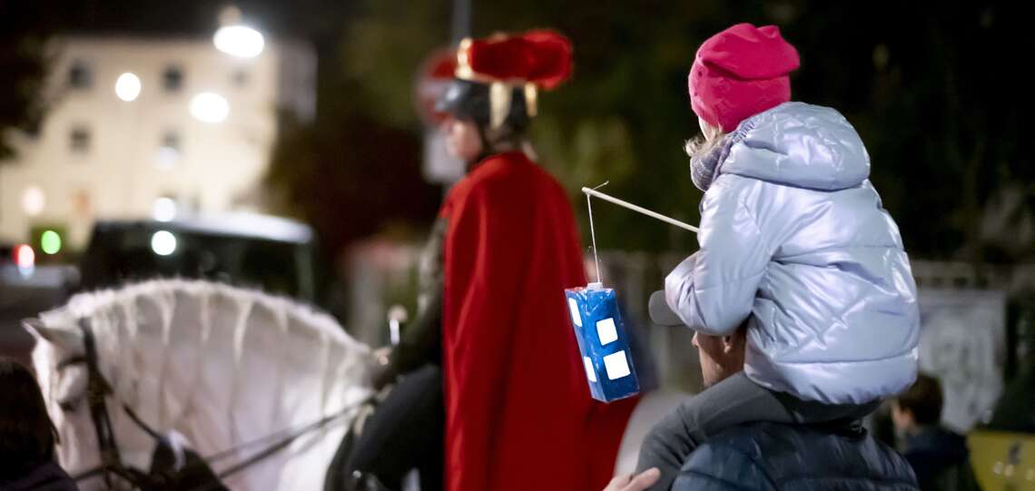 Kind mit Laterne auf den Schultern eines Mannes beim Martinsumzug Kind mit Laterne auf den Schultern eines Mannes beim Martinsumzug