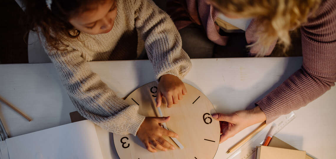 Mutter und Kind mit Holzuhr