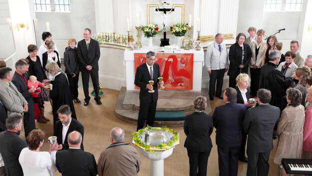 In der Philippuskirchgemeinde Lohmen steht die gemeinde zusammen um den Altar zum Abendmahl in der Dorfkirche 