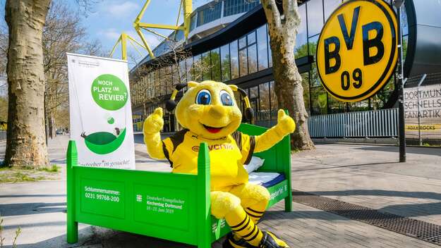 BvB-Maskottchen Emma wirbt vor dem Stadion für die Bettenkampagne 