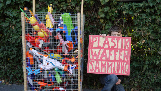 Plastikwaffensammlung, Behälter und Schild