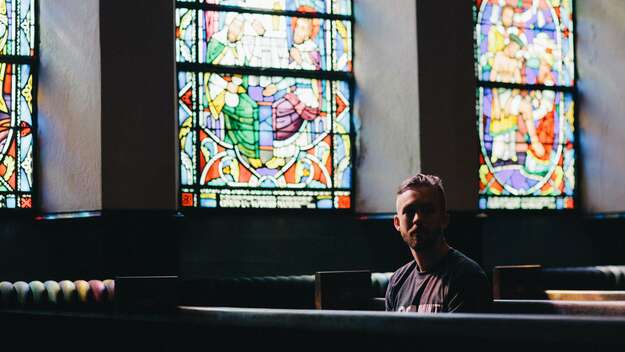 Mann sitzt in einer Kirche