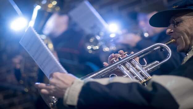 Blasorchester beim Laternenumzug. Im Vordergrund ein Musiker mit silberner Trompete in der rechten Hand und das Notenblatt in der linken Hand. 