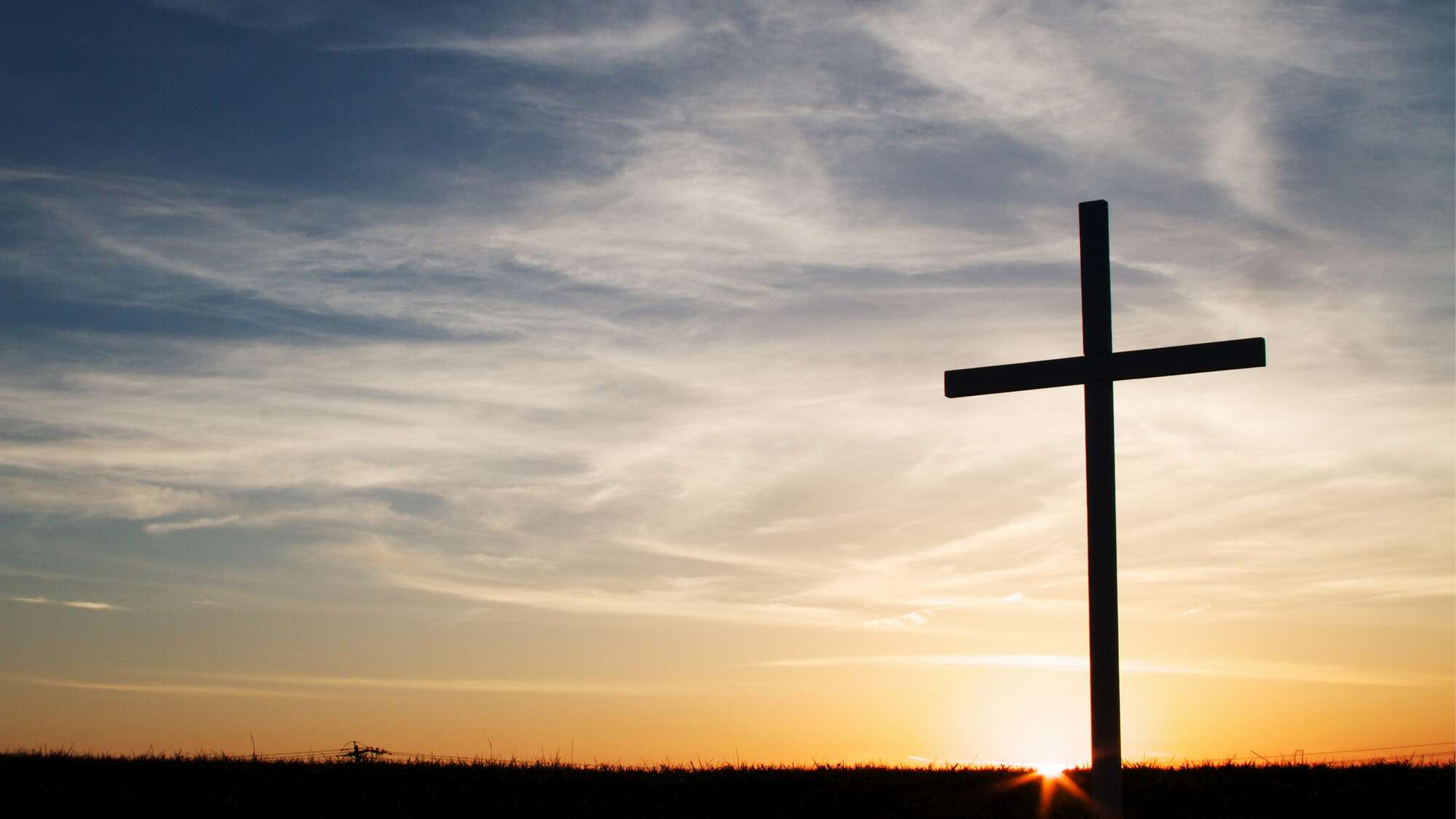 Ein Kreuz vor Sonnenaufgang