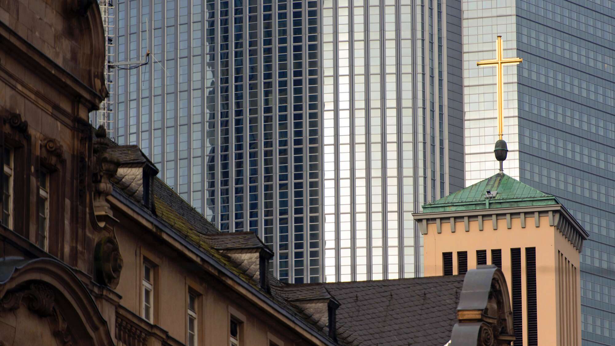 Turmkreuz der evangelischen Matthäuskirche vor Banken- und Bürogebäuden in Frankfurt am Main