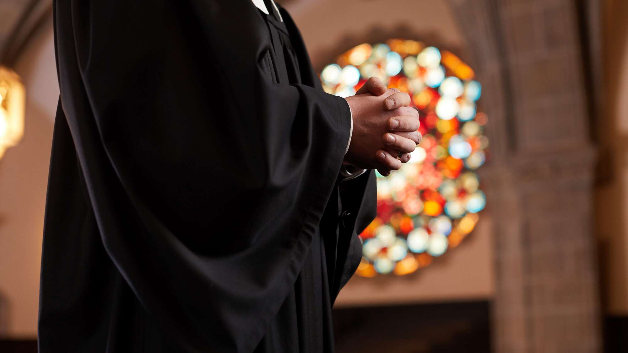 Priest in church praying.